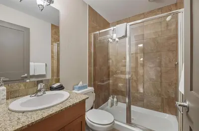 a bathroom with a toilet sink and a shower at Beautiful Peak Vista - 2BR w Stunning Mt Views in Canmore