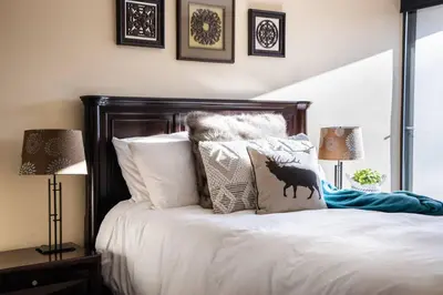 a bedroom with a bed with white sheets and pillows at Mountain View Penthouse- 2BR Oasis at the Marquise in Whistler in Whistler