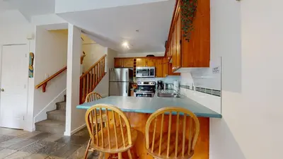 a kitchen with wooden cabinets and a blue counter top at 2BR in Symphony, Whistler Village, Complex Hot Tub, Gas Fireplace, Parking, Gondola Shuttle in Whistler