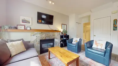 a living room with a couch and chairs and a fireplace at 2BR in Symphony, Whistler Village, Complex Hot Tub, Gas Fireplace, Parking, Gondola Shuttle in Whistler