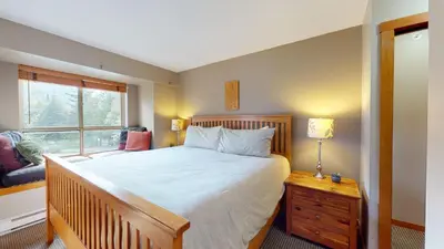 a bedroom with a large bed and a window at 2BR in Symphony, Whistler Village, Complex Hot Tub, Gas Fireplace, Parking, Gondola Shuttle in Whistler