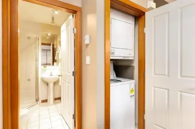 a bathroom with a sink and a washer and dryer at 2BR in Symphony, Whistler Village, Complex Hot Tub, Gas Fireplace, Parking, Gondola Shuttle in Whistler