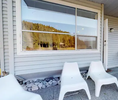 two white chairs sitting in front of a window at 1BR and Sofabed at Whistler on the Lake, Lakefront, Serene Setting, Wood Burning Fireplace in Whistler