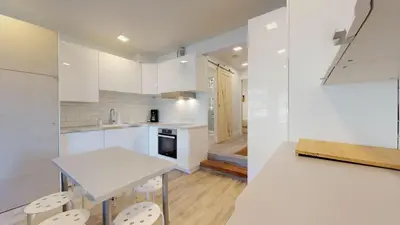 a kitchen with white cabinets and a table and chairs at 1BR and Sofabed at Whistler on the Lake, Lakefront, Serene Setting, Wood Burning Fireplace in Whistler