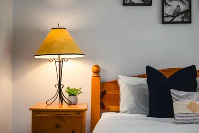a lamp on a night stand next to a bed at 1BR in Northstar, Village Location, Gas Fireplace, Shared Hot Tub, Ski Storage in Whistler