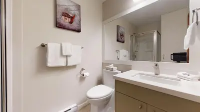 a white bathroom with a toilet and a sink at 2BR in Northstar, Whistler Village, Fireplace, Hot Tub, Central Location, Ski Storage in Whistler