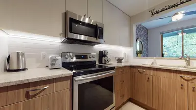 a kitchen with a stove and a microwave at 2BR in Northstar, Whistler Village, Fireplace, Hot Tub, Central Location, Ski Storage in Whistler