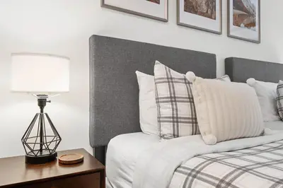 a bedroom with a bed and a lamp on a table at 2BR in The Aspens, Ski In, Ski Out, Pool and Hot Tub, Gas Fireplace, Ski Valet, Gym in Whistler