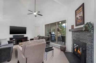 a living room with a fireplace and a tv at 3BR in Gleneagle, Soaker Tub with Skylight, Wood Burning Fireplace, Spacious Layout in Whistler