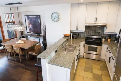 a kitchen with a table and a dining room at 3BR Luxury Home in Taluswood, Hot Tub, Ski In, Ski Out, Two-Car Garage, Village Parking in Whistler