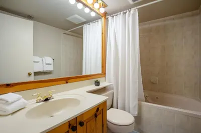 a bathroom with a sink and a toilet and a mirror at 3BR in Foxglove, Wood Burning Fireplace, Mudroom, Near Gondola, Parking in Whistler