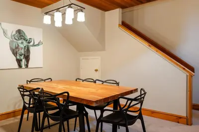 a dining room with a wooden table and chairs at 3BR in Foxglove, Wood Burning Fireplace, Mudroom, Near Gondola, Parking in Whistler