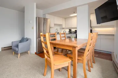 a kitchen and dining room with a wooden table and chairs at 1BR in Carleton Lodge, Unbeatable Mountain Base Location, Ski In, Ski Out, Free Parking in Whistler