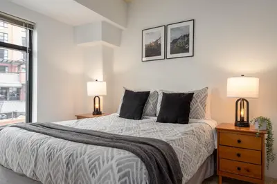 a white bedroom with a bed and two lamps at 1BR in Carleton Lodge, Unbeatable Mountain Base Location, Ski In, Ski Out, Free Parking in Whistler