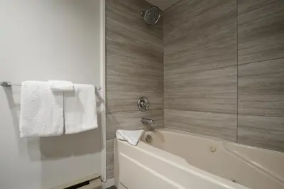 a bathroom with a white tub and a shower at 2BR in Powderhorn, Near Blackcomb, Double-Sided Fireplace, Rooftop Hot Tub, Parking in Whistler