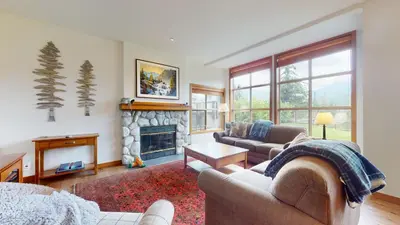 a living room with two couches and a fireplace at 2BR in Blackcomb Greens, Wood Burning Fireplace, Communal Hot Tub, Nature Views in Whistler