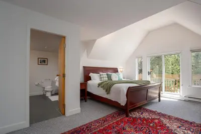 a bedroom with a bed and a bathroom at 3BR in Alpine Greens, Soaker Tub, Wood Burning Fireplace, Family Sized in Whistler