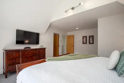 a bedroom with a bed and a flat screen tv at 3BR in Alpine Greens, Soaker Tub, Wood Burning Fireplace, Family Sized in Whistler