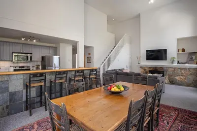 a kitchen and dining room with a wooden table and chairs at 3BR in Alpine Greens, Soaker Tub, Wood Burning Fireplace, Family Sized in Whistler