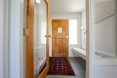 a hallway with a wooden door and a rug at 3BR in Alpine Greens, Soaker Tub, Wood Burning Fireplace, Family Sized in Whistler