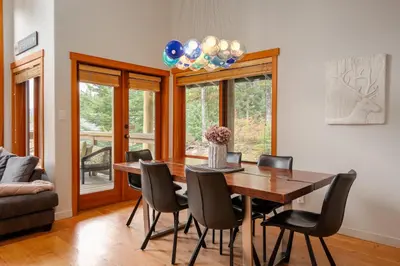 a dining room with a wooden table and chairs at Luxury Mountain Retreat with PRIVATE Hot Tub by Harmony Whistler in Whistler