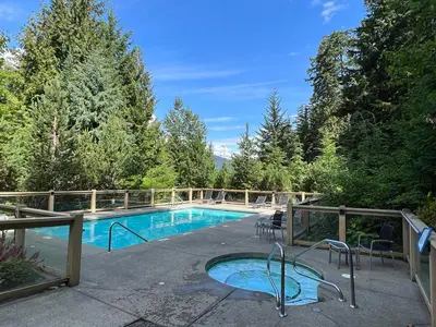 a swimming pool in the middle of a yard at Luxury Mountain Retreat with PRIVATE Hot Tub by Harmony Whistler in Whistler