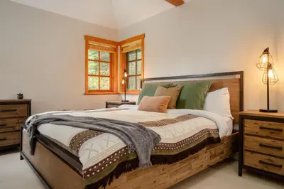 a bedroom with a large bed and a window at Luxury Mountain Retreat with PRIVATE Hot Tub by Harmony Whistler in Whistler