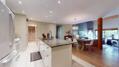 a kitchen with a counter top and a living room at 2BR in Ironwood, Fireplace, Common Area Hot Tub, Private Patio, Parking in Whistler