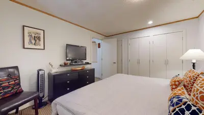 a bedroom with a bed and a tv and a chair at 2BR plus Den in The Gables, Unbeatable Location Near Gondolas, Private Balcony, Secure Parking in Whistler