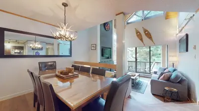 a dining room and living room with a table and chairs at 2BR plus Den in The Gables, Unbeatable Location Near Gondolas, Private Balcony, Secure Parking in Whistler