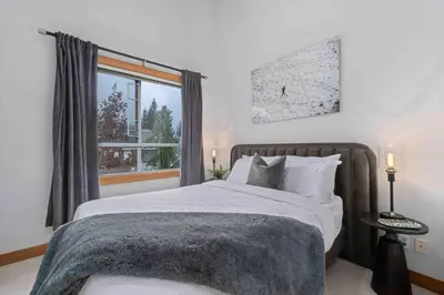 a bedroom with a large bed and a window at 2BR in Granite Court, Village Location, King Bed, Private Balcony, Parking, Fireplace in Whistler
