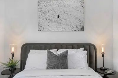 a bed with white pillows and a picture on the wall at 2BR in Granite Court, Village Location, King Bed, Private Balcony, Parking, Fireplace in Whistler