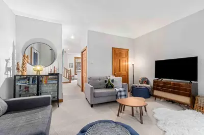 a living room with a tv and a couch and a table at 2BR in Granite Court, Village Location, King Bed, Private Balcony, Parking, Fireplace in Whistler