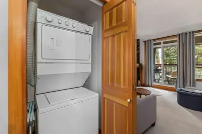 a kitchen with a white stove and a refrigerator at 2BR in Granite Court, Village Location, King Bed, Private Balcony, Parking, Fireplace in Whistler