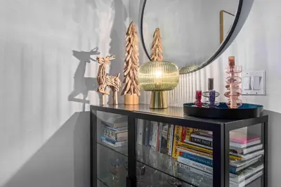 a book shelf with a mirror and books at 2BR in Granite Court, Village Location, King Bed, Private Balcony, Parking, Fireplace in Whistler
