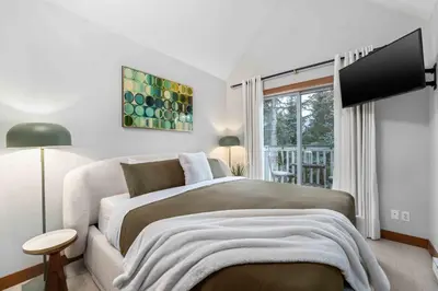 a bedroom with a large bed and a window at 2BR in Granite Court, Village Location, King Bed, Private Balcony, Parking, Fireplace in Whistler