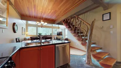 a kitchen with a sink and a spiral staircase at 3BR in Greystone Lodge, Ski In, Ski Out, Pool and Hot Tub, Epic Location in Whistler