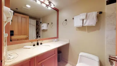 a bathroom with a sink and a toilet and a mirror at 3BR in Greystone Lodge, Ski In, Ski Out, Pool and Hot Tub, Epic Location in Whistler