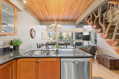 a kitchen with a sink and a living room at 3BR in Greystone Lodge, Ski In, Ski Out, Pool and Hot Tub, Epic Location in Whistler