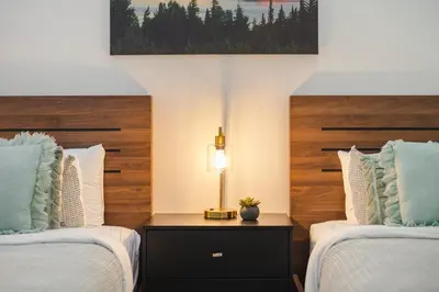 a bedroom with two beds and a lamp on a night stand at 2BR plus Loft in Wildwood Lodge, Free Ski Bus, Hot Tub and Pool, Private Patio, Parking in Whistler