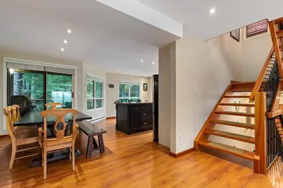 a kitchen and dining room with a table and a staircase at 4BR in Blueberry Hill Estates, Lake View, Tranquil Setting, Gourmet Kitchen, Family Sized in Whistler