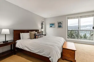 a bedroom with a large bed and a window at 4BR in Blueberry Hill Estates, Lake View, Tranquil Setting, Gourmet Kitchen, Family Sized in Whistler