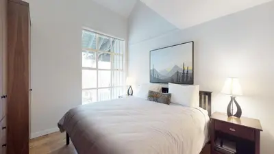 a white bedroom with a large bed and a window at 1BR plus Loft in Glacier Lodge, King Bed, Near Gondola, Private Balcony, Free Ski Valet in Whistler