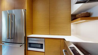 a kitchen with wooden cabinets and a stainless steel refrigerator at 2BR in The Gables, Steps to Gondolas, Heated Floors, Private Balcony, Fireplace in Whistler