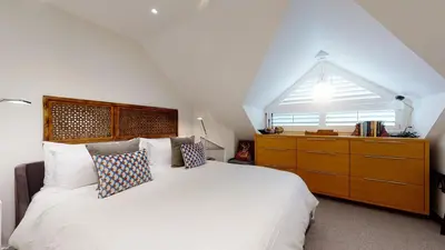 a bedroom with a large white bed and a dresser at 2BR in The Gables, Steps to Gondolas, Heated Floors, Private Balcony, Fireplace in Whistler