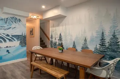a dining room with a winter mural on the wall at 2BR plus Loft in Valhalla, Village Location, Covered Patio, King Bed, Hot Tub in Whistler