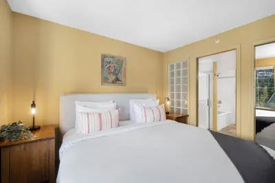a bedroom with a large white bed and a tub at 2BR in The Lynx, Family Sized, Mountain Views, Private Balcony, Tranquil Location, Parking in Whistler