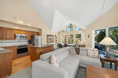 a living room with a couch and a kitchen at 2BR in The Lynx, Family Sized, Mountain Views, Private Balcony, Tranquil Location, Parking in Whistler