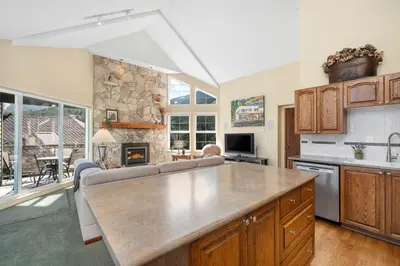 a kitchen and living room with a couch and a table at 2BR in The Lynx, Family Sized, Mountain Views, Private Balcony, Tranquil Location, Parking in Whistler