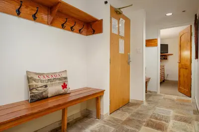 a hallway with a wooden bench in a room at 2BR plus Den in Woodrun, True Ski In, Ski Out, Heated Floors, Pool and Hot Tub, King Ensuite in Whistler